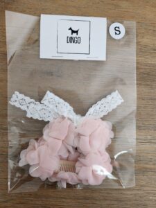 A bag of pink hair clips with white lace.