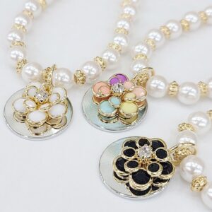 A close up of three necklaces with pearls