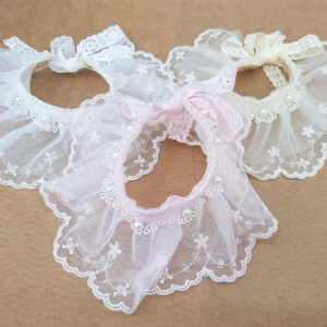 A group of three white and pink baby bibs.